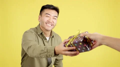 Happy chinese man smiling while receiving a gift Видео 234859810