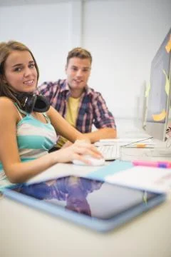 Happy classmates doing assignment together in the computer room Stock Photos
