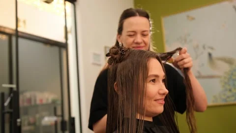 Happy client smiling while getting her hair styled at a professional beauty 스톡 동영상 318288918