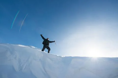 Happy climber with an ice ax in the snowy mountains Stock Photos