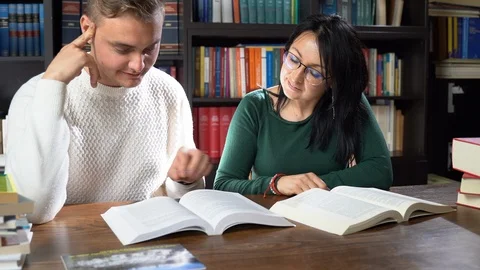 Happy college students working with different books in library Stock Footage 107685816