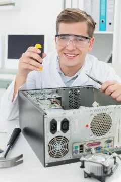 Happy  computer engineer working on broken device Stock Photos