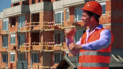 Happy construction worker dances in front of building site Video stock 79050910