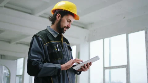 Happy constructor worker man holding digital tablet to analysing some work at Stock Footage 171799954