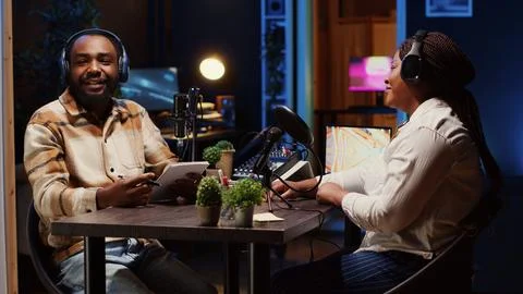 Happy content creator using professional audio gear, presenting interviewee Stock Photos