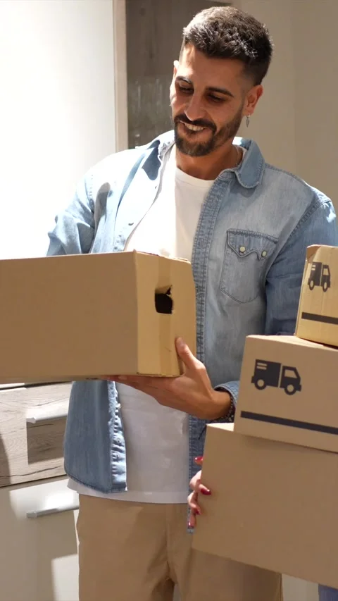 Happy couple arranging cardboard boxes in new home Stock Footage 302927995