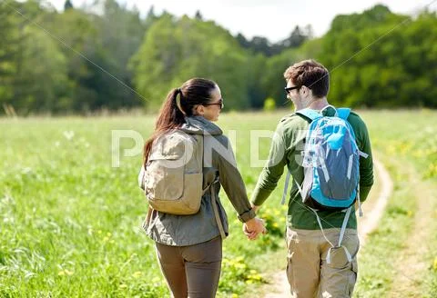 Happy couple with backpacks hiking outdoors Stock Photos