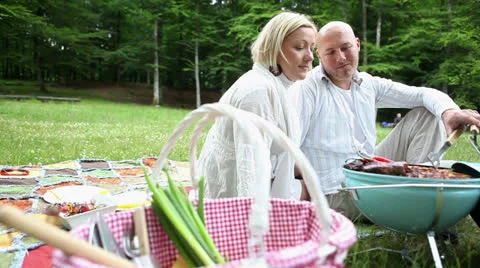 Happy couple with bbq in park Stock Footage 24696368