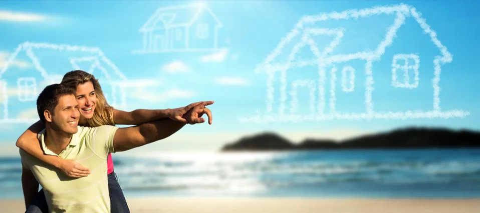 Happy couple on the beach dreaming of a house. Stock Photos