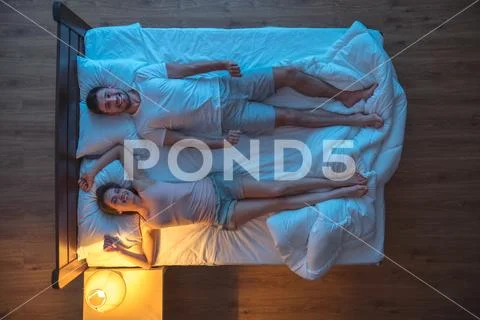 The happy couple on the bed. evening night time. view from above Stock Photos