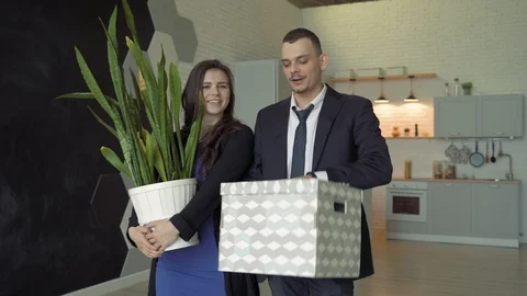 Happy couple bringing boxes with things and the flower in new apartment. Stock Footage 119339396