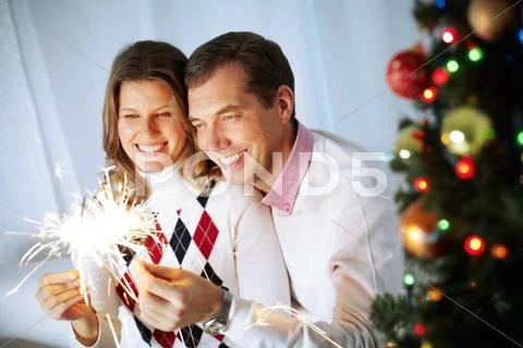 Happy couple burning Bengal lights on Christmas Eve Stock Photos