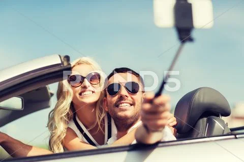 Happy couple in car taking selfie with smartphone Stock Photos
