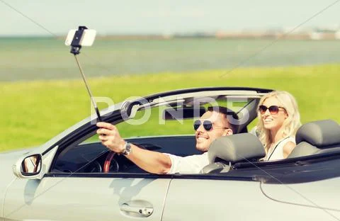 Happy couple in car taking selfie with smartphone Stock Photos