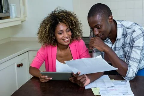 Happy couple checking bills while using digital tablet Foto stock