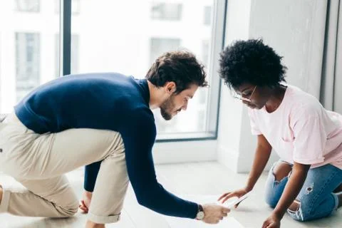 Happy couple checking bills while using digital tablet in kitchen Stock Photos