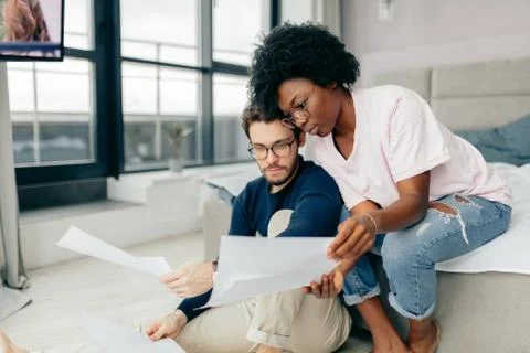 Happy couple checking bills while using digital tablet in kitchen Foto stock