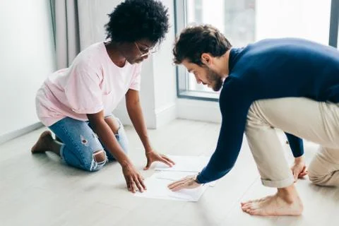 Happy couple checking bills while using digital tablet in kitchen Stock Photos