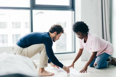 Happy couple checking bills while using digital tablet in kitchen Stock Photos