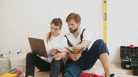 Happy Couple Choosing Design Of Their New Flat, Using Color Palette And Laptop Stock Footage 232229688