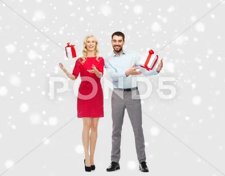 Happy couple with christmas gift boxes over snow Stock Photos