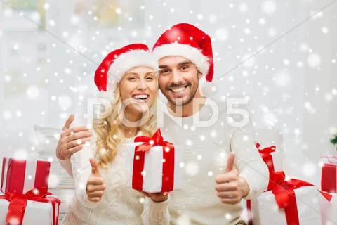 Happy couple with christmas gifts and thumbs up Stock Photos
