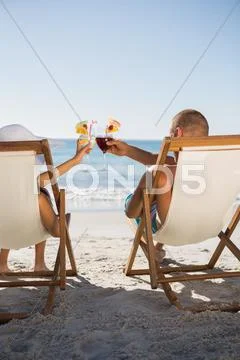 Happy couple clinking their glasses Stock Photos