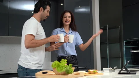 Happy couple cooking breakfast drinking coffee and dancing together in loft k Stock Footage 168664773