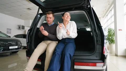 Happy couple dancing and hugging after buying new car Stock Footage 303384060