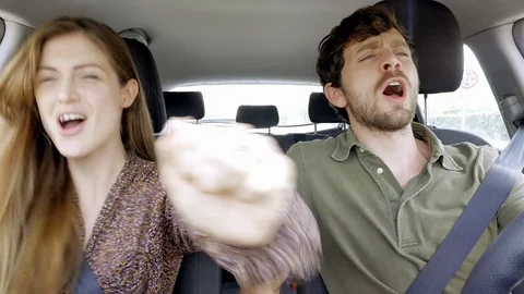 Happy couple dancing and singing like crazy in car having fun Stock Footage 69868150
