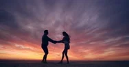 Happy Couple Dancing On Beach Enjoying Honeymoon In Nature At Sunset Silhouetted Stock Footage