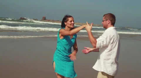 Happy couple dancing on the beach, steadicam shot Video stock 10893183