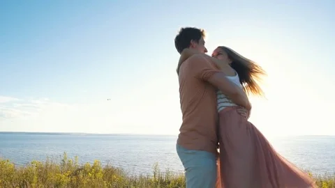 Happy couple dancing at the edge of the cliff on the background of the river Stock Footage 77129801