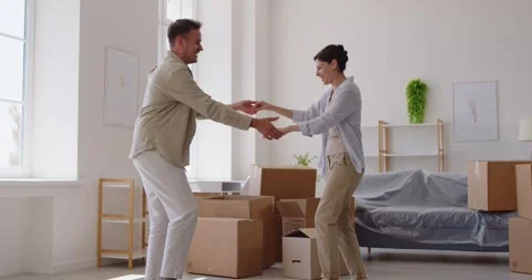 Happy couple dancing, holding hands to spin around in dance, celebrate Stockbeeldmateriaal 327854987