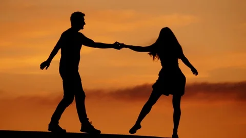 Happy couple dancing silhouettes, series of swingout moves, slow motion shot Stock Footage