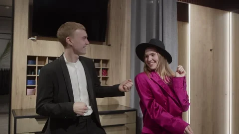 Happy couple dancing while trying new clothes in clothing store Stock Footage 297471414