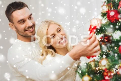 Happy couple decorating christmas tree at home Stock Photos