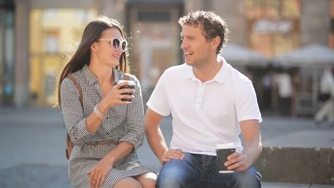 Happy Couple Drinking Coffee Sitting on the Bench on the City Square During Stock Footage 82043010