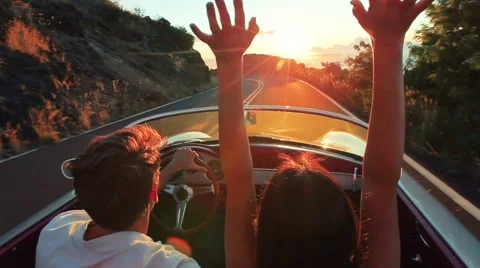 Happy Couple Driving Classic Convertible Car into Sunset on Country Road Stock Footage