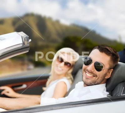 Happy couple driving in convertible car Stock Photos