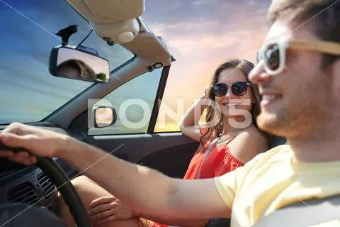 Happy couple driving in convertible car Stock Photos