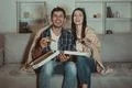 The happy couple eating a pizza and watch a movie on the sofa Photo