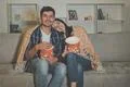 The happy couple eating popcorn and watch movie on the sofa Photo