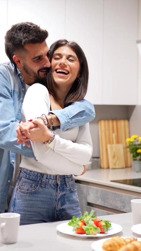 Happy couple embracing in kitchen during breakfast Stock Footage 302928034