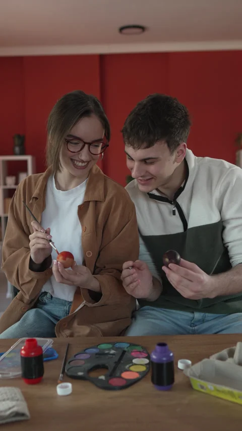 Happy couple enjoy while paint decorative easter egg in living room Stock Footage 301917226