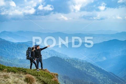 The happy couple gesturing on the cliff Stock Photos