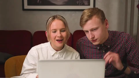 Happy couple has video call chatting with friends and family on laptop at home Stock Footage 146602553