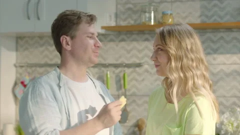Happy couple having breakfast, man feeding his partner with cheese Stock Footage 196704287