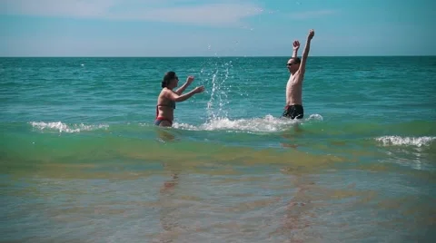 Happy Couple Having Fun on Ocean Waves Stock Footage 55449966