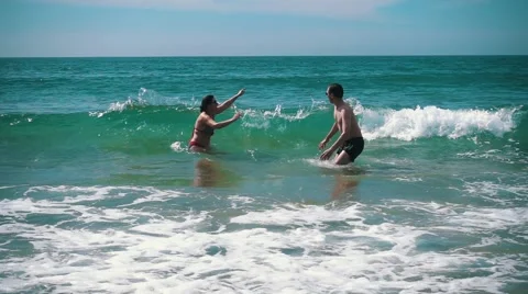 Happy Couple Having Fun on Ocean Waves Stock Footage 55450004